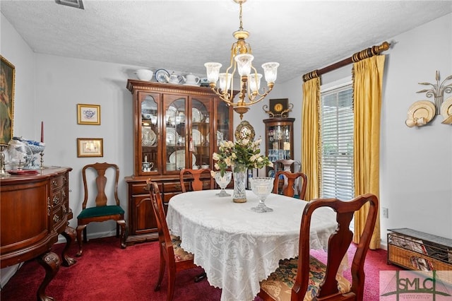 carpeted dining room featuring a textured ceiling and a chandelier