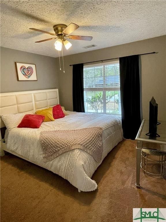 bedroom with ceiling fan, a textured ceiling, and carpet