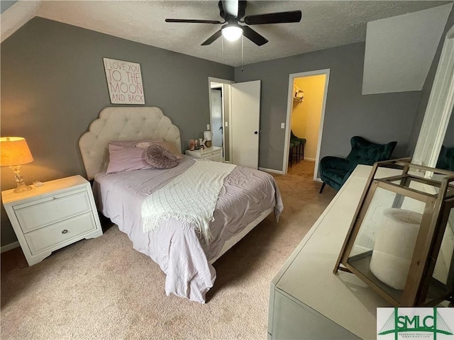 carpeted bedroom with ceiling fan, a spacious closet, a closet, and a textured ceiling