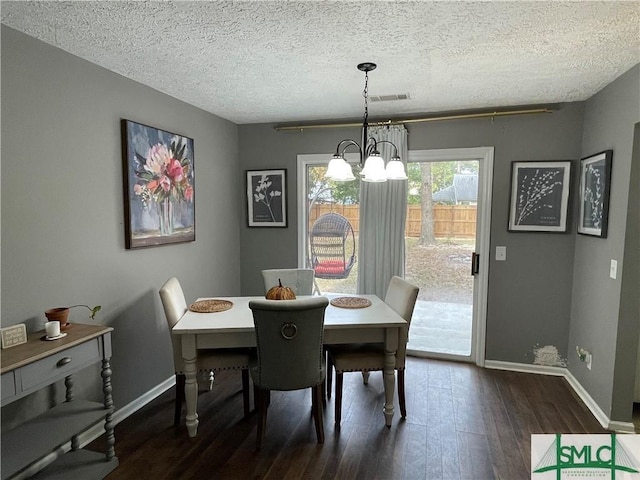 dining area featuring a notable chandelier, dark hardwood / wood-style floors, and a textured ceiling