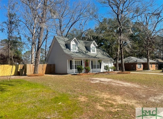 new england style home with a garage, fence, and a front lawn