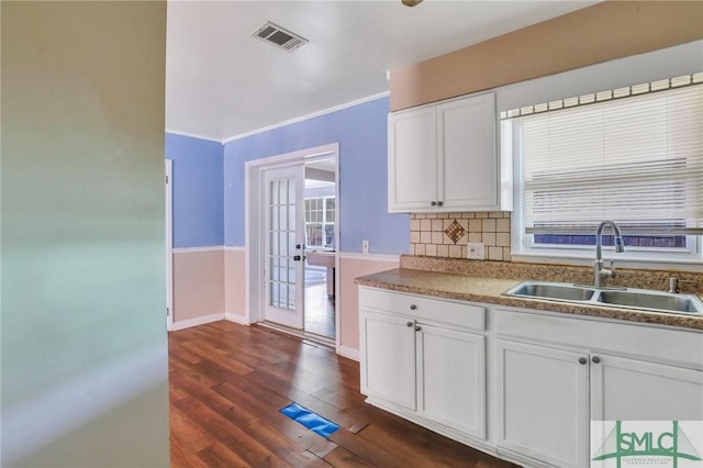 108 Stafford St, Hinesville, GA 31313 - kitchen featuring sink, dark wood-type flooring, white cabinetry, tasteful backsplash, and ornamental molding