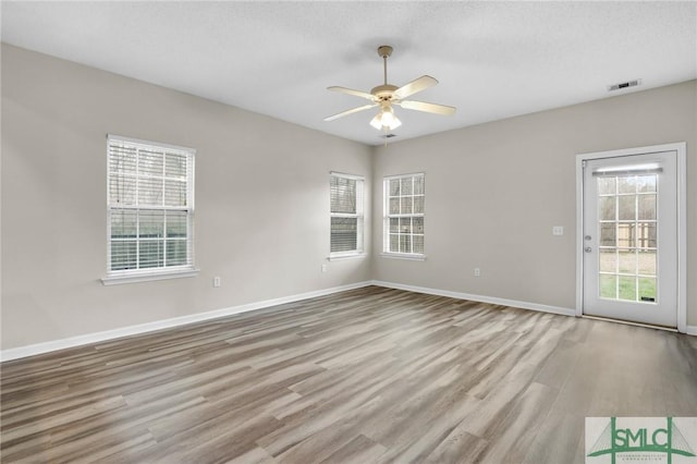 spare room with ceiling fan, light hardwood / wood-style floors, and a textured ceiling