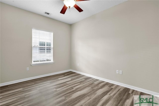 spare room featuring a textured ceiling, wood-type flooring, and ceiling fan