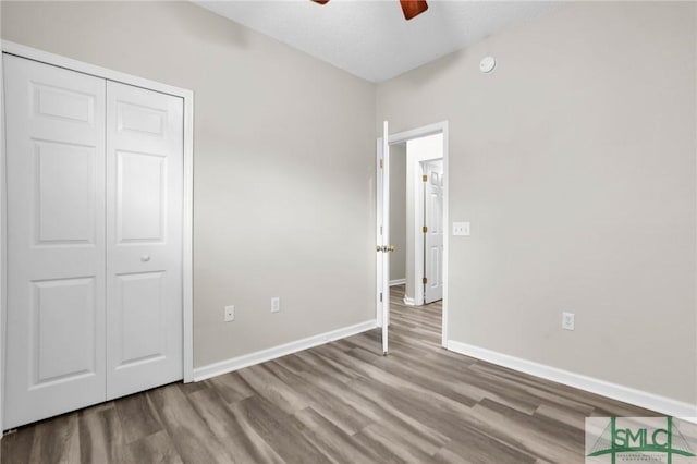 unfurnished bedroom featuring ceiling fan, light hardwood / wood-style floors, and a closet