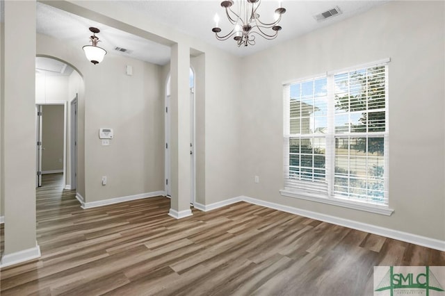 unfurnished dining area featuring hardwood / wood-style floors and a chandelier