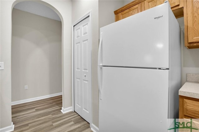 kitchen with light hardwood / wood-style floors and white fridge