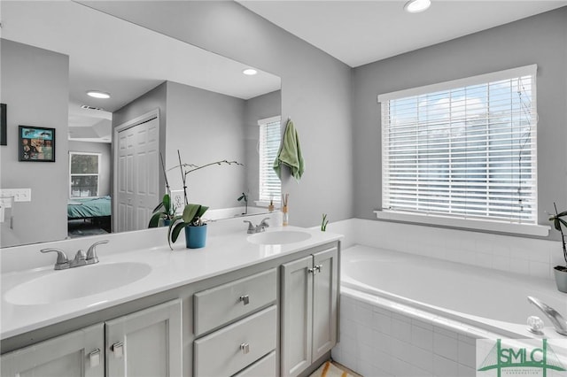 bathroom featuring vanity and tiled bath