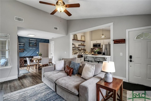 living room featuring dark wood-type flooring, ceiling fan, and lofted ceiling