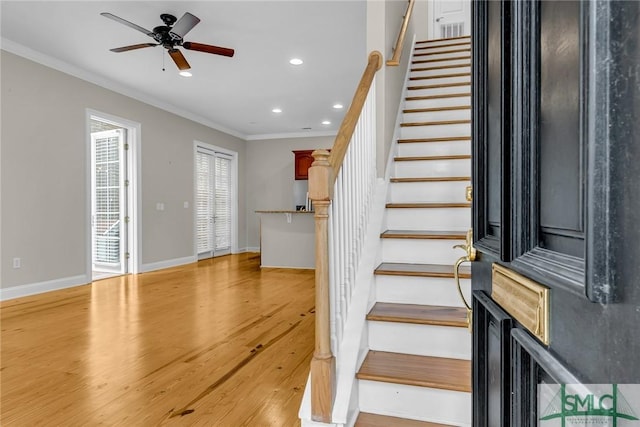 staircase featuring hardwood / wood-style flooring, ornamental molding, and ceiling fan