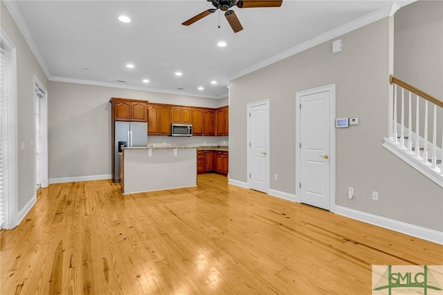 kitchen with ceiling fan, appliances with stainless steel finishes, ornamental molding, a kitchen island, and light wood-type flooring