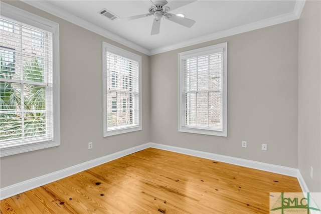 spare room with crown molding, plenty of natural light, and hardwood / wood-style flooring