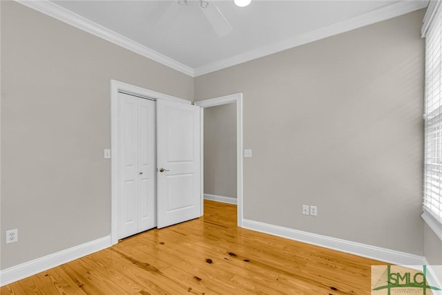 unfurnished bedroom featuring hardwood / wood-style flooring, ornamental molding, a closet, and ceiling fan