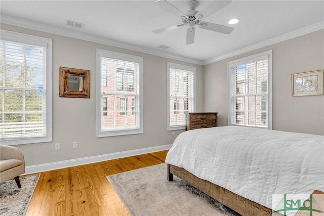 bedroom with crown molding, ceiling fan, and hardwood / wood-style flooring