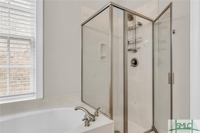 bathroom with separate shower and tub and a wealth of natural light