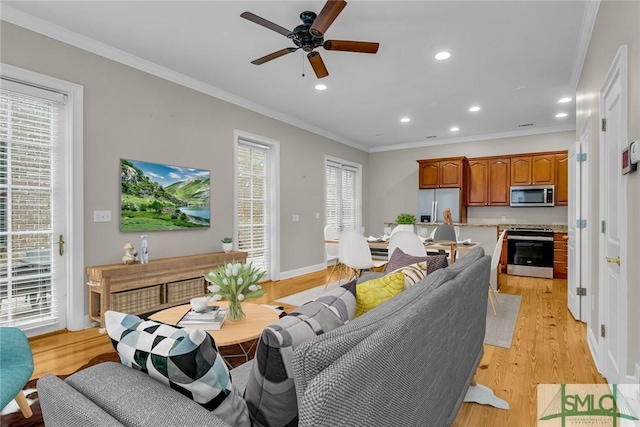 living room featuring crown molding, ceiling fan, and light hardwood / wood-style floors