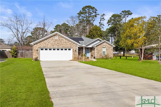 ranch-style home featuring a garage, a front lawn, and solar panels