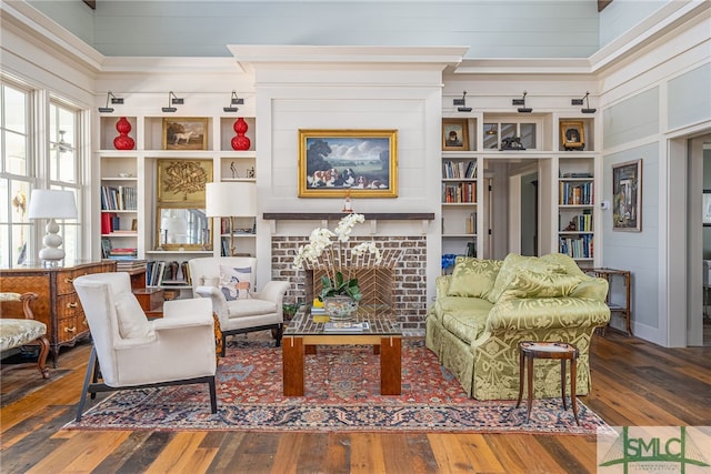 living area with a brick fireplace and hardwood / wood-style flooring