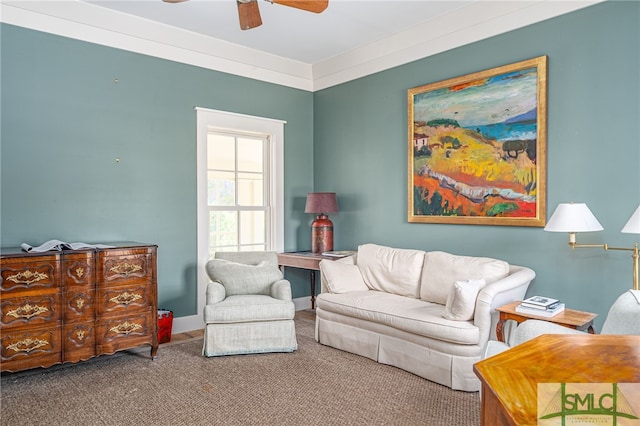 living area featuring a ceiling fan, carpet flooring, crown molding, and baseboards