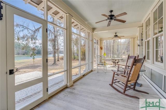 sunroom / solarium with a water view and a ceiling fan