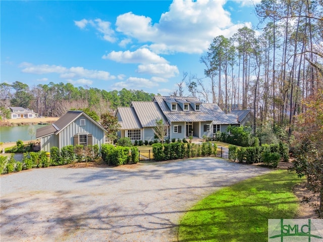 view of front of home featuring gravel driveway, a water view, board and batten siding, a standing seam roof, and metal roof