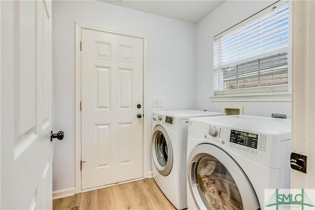 washroom with light hardwood / wood-style flooring and washer and dryer