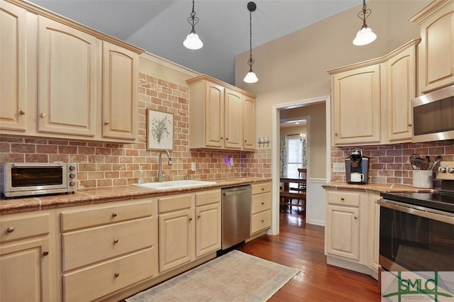 kitchen featuring stainless steel appliances, sink, dark hardwood / wood-style floors, and decorative light fixtures