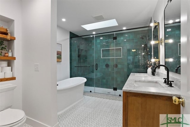 full bathroom featuring a skylight, vanity, toilet, and independent shower and bath