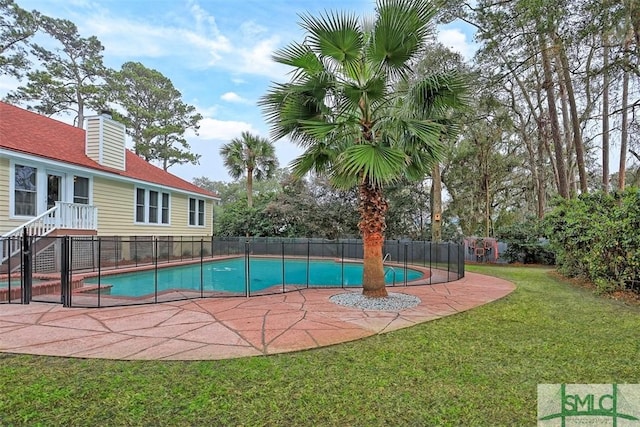 view of swimming pool with a yard