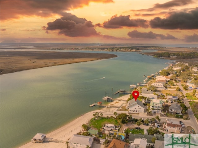 aerial view at dusk with a beach view and a water view