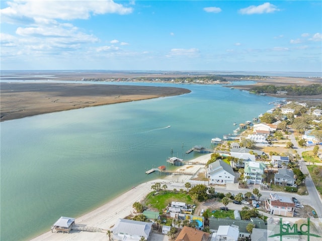 birds eye view of property with a water view and a beach view