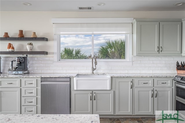 kitchen featuring light stone counters, appliances with stainless steel finishes, sink, and tasteful backsplash