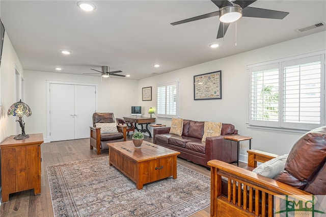 living room featuring ceiling fan and light hardwood / wood-style flooring