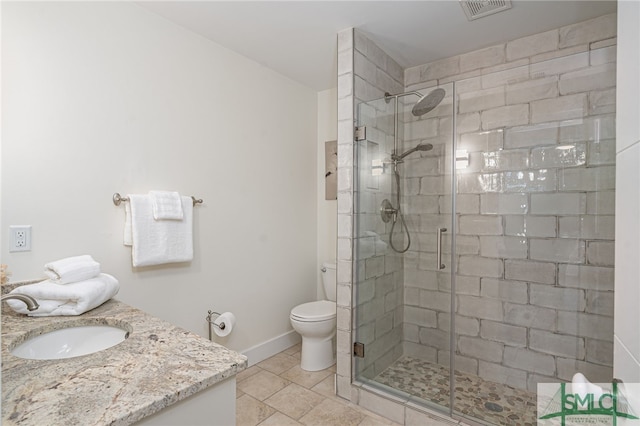 bathroom with tile patterned flooring, vanity, a shower with shower door, and toilet