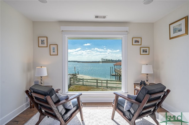 living area with a water view and light wood-type flooring