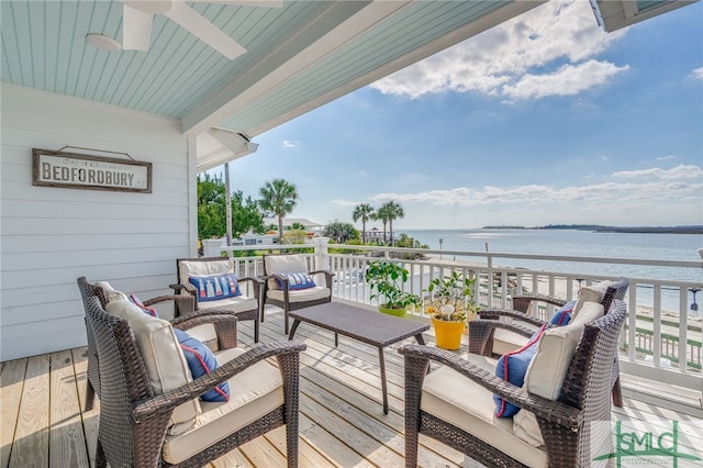 wooden terrace featuring a water view, ceiling fan, and an outdoor living space