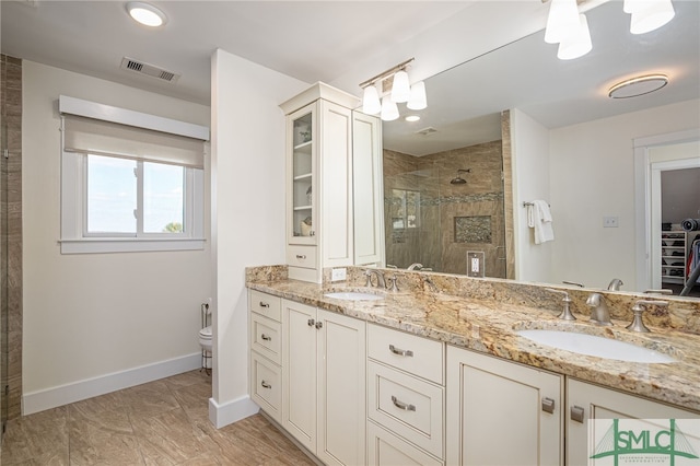 bathroom featuring a shower with door and vanity