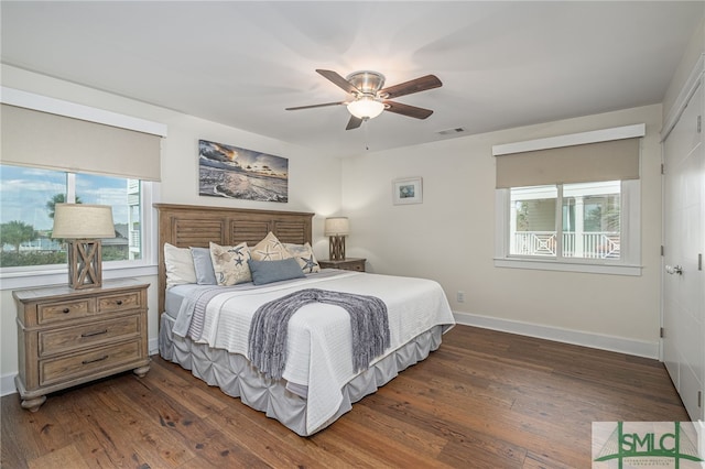 bedroom with multiple windows, ceiling fan, and dark hardwood / wood-style flooring