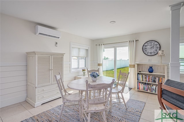 dining space featuring wooden walls, a wall mounted AC, and light tile patterned flooring