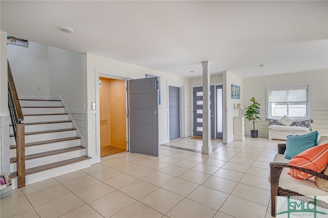 entrance foyer with decorative columns and light tile patterned floors