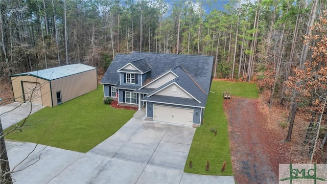 view of front of property with a garage, an outdoor structure, and a front yard