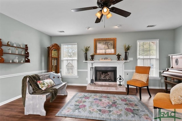 living area with plenty of natural light, dark hardwood / wood-style floors, and ceiling fan