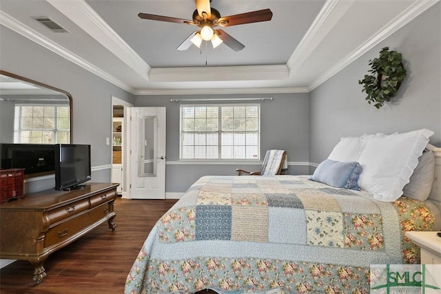 bedroom with dark hardwood / wood-style floors, ceiling fan, a tray ceiling, and crown molding