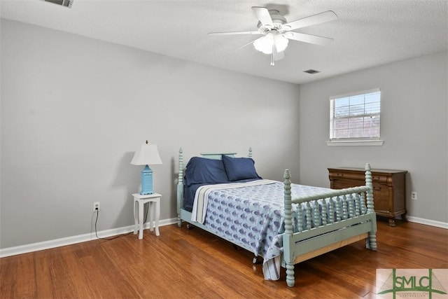 bedroom featuring a textured ceiling, wood-type flooring, and ceiling fan