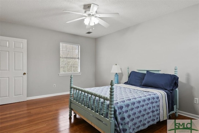 bedroom with dark wood-type flooring, ceiling fan, and a textured ceiling