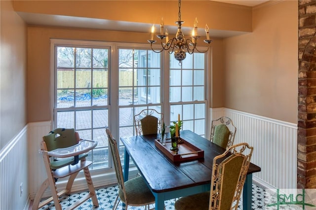 dining space with crown molding and a chandelier