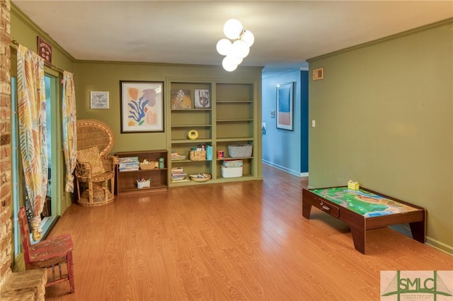 playroom with ornamental molding and hardwood / wood-style floors