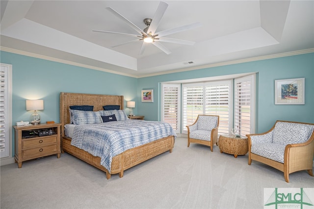 carpeted bedroom with a raised ceiling, ornamental molding, and ceiling fan