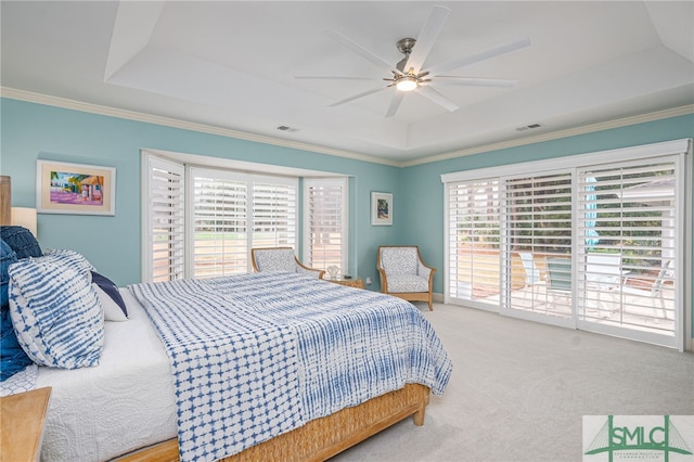 bedroom featuring a raised ceiling, ornamental molding, access to outside, and multiple windows