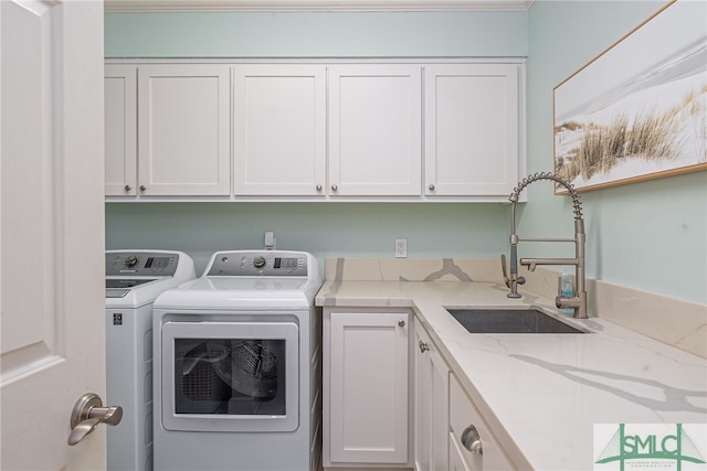 laundry area featuring cabinets, sink, and washing machine and clothes dryer